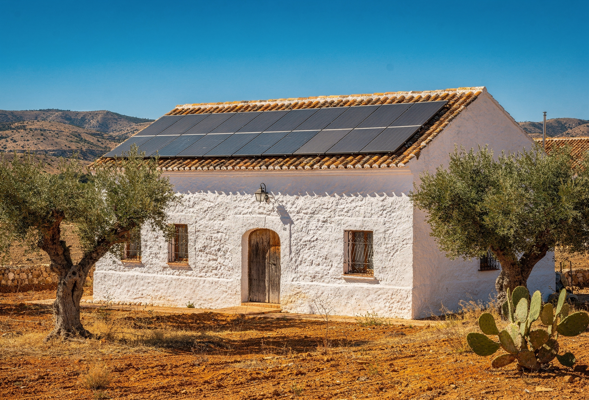 Casa rural andaluza encalada con placas solares en el tejado